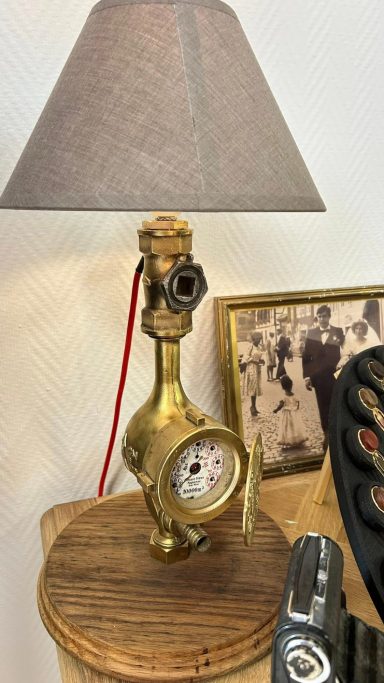 Lampe vintage en métal doré avec un abat-jour gris et une horloge intégrée.