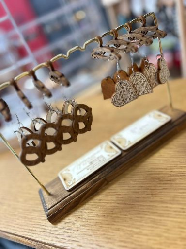 Support en bois avec des décorations en forme de cœur et de bonhomme en pain d'épice.