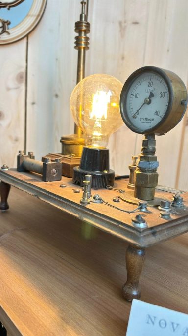 Appareil ancien avec une ampoule et un manomètre sur une table en bois.