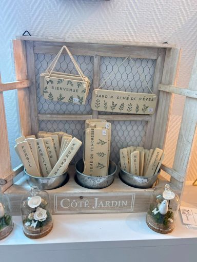 Panneau en bois avec étiquettes et petites décorations florales.