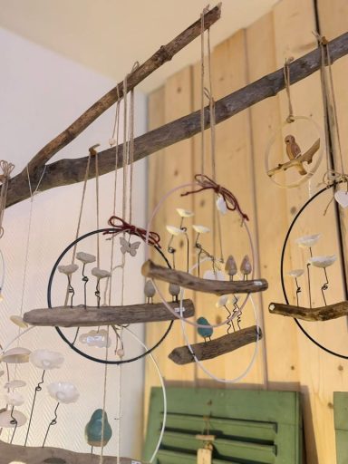 Suspension décor en bois avec des éléments en verre et des cercles métalliques.