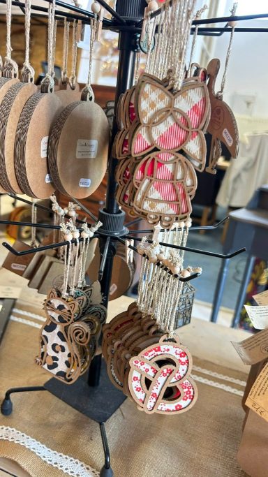 Décoration de Noël en forme de biscuits accrochée à un présentoir rotatif.